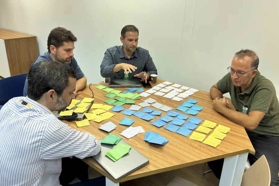 Participantes de um workshop organizando cartões sobre uma mesa