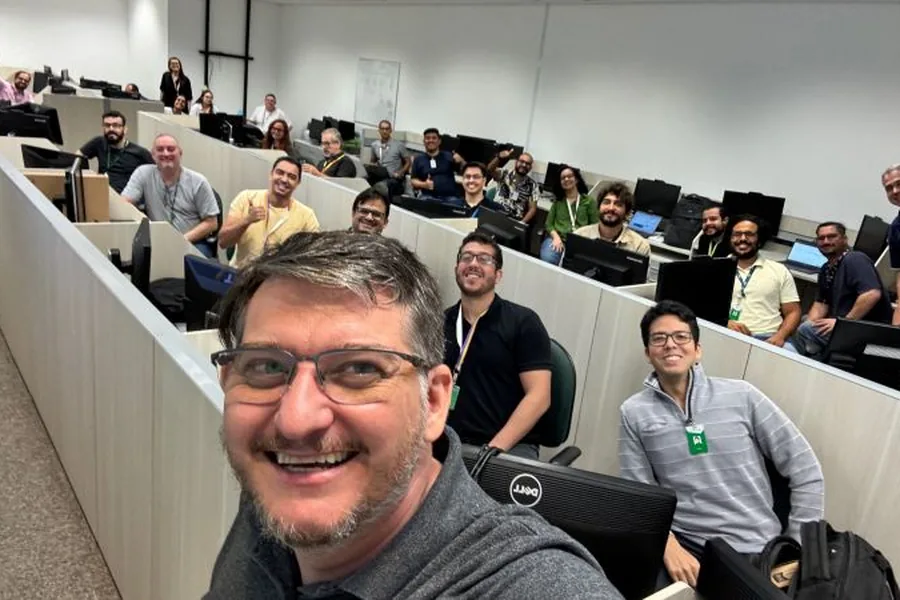 Turma numa sala de treinamento, sorrindo para a foto