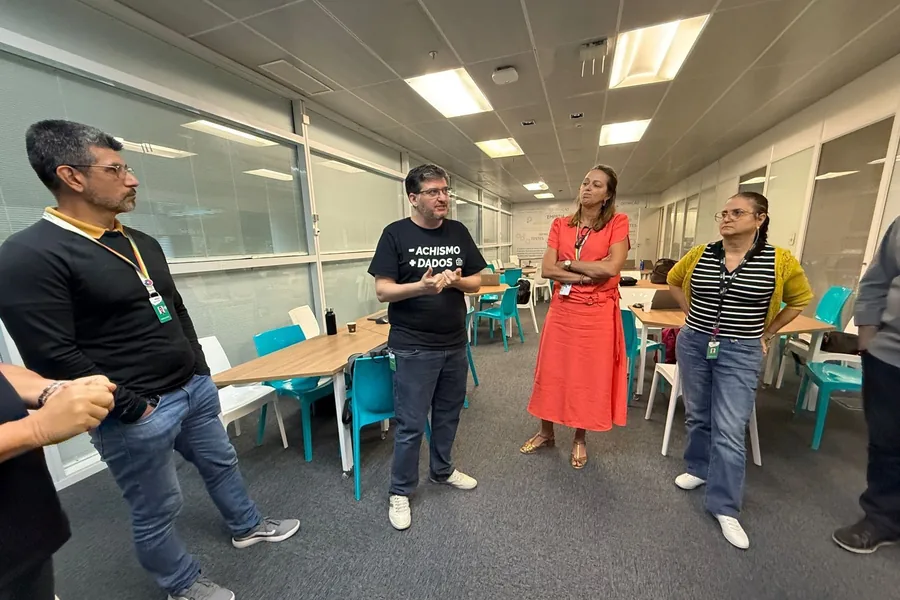 Aislan Greca conversando com um grupo pequeno numa sala de inovação